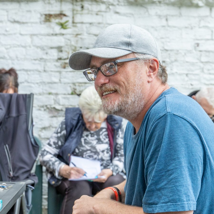Close-up portrait of a man outdoors wearing a cap.