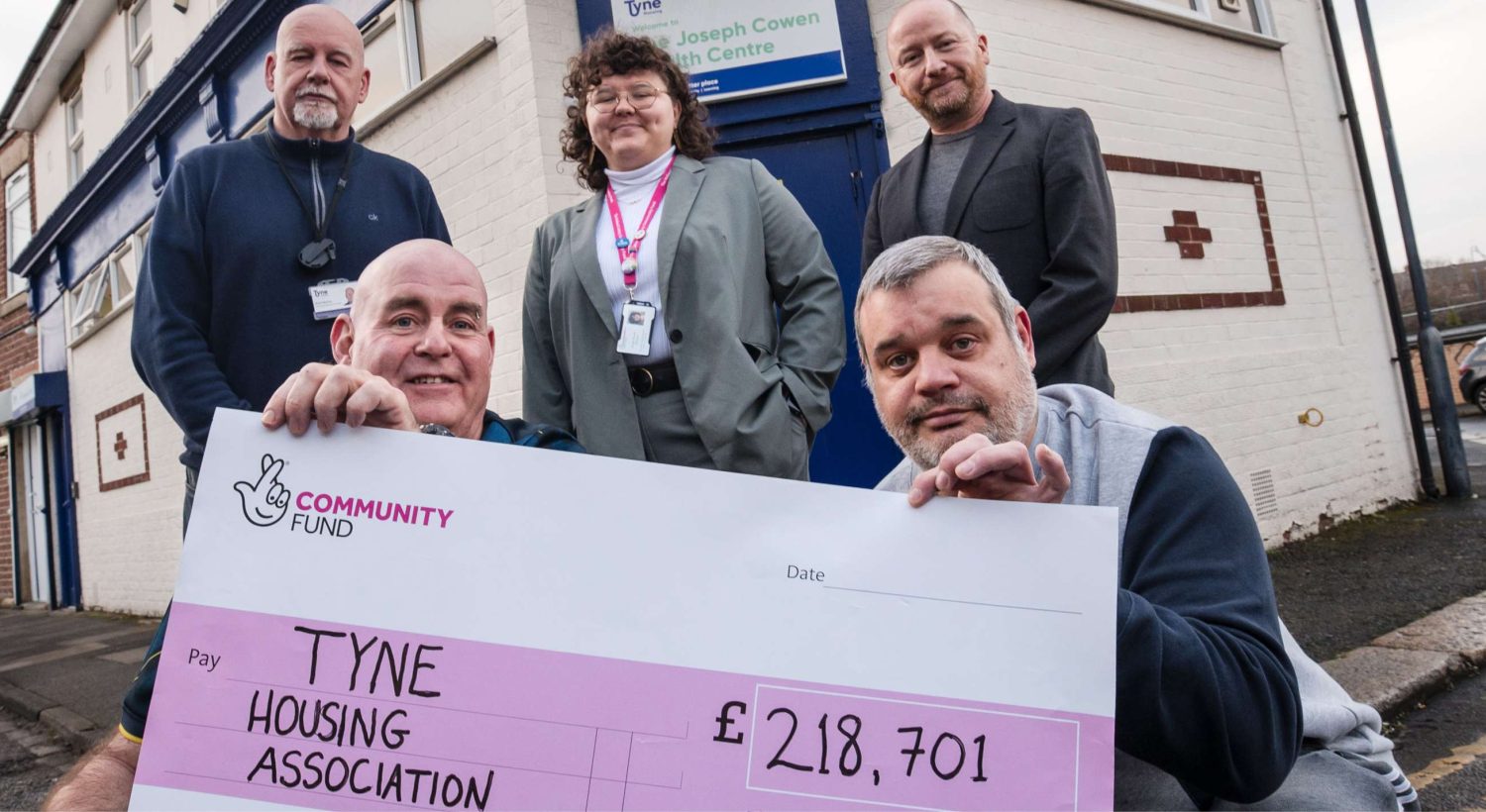 People smiling holding a donation.